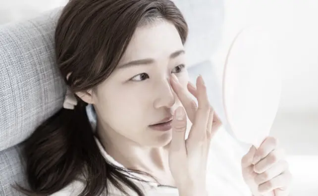 顔を気にする女性の写真